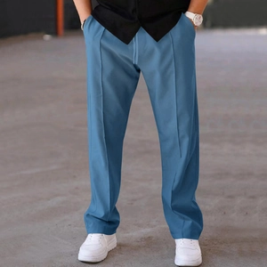 Detail of blue straight casual trousers with elastic drawstring waist and vertical creases