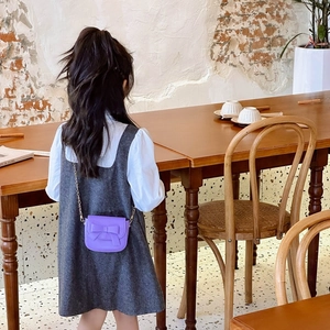 Mini purple girls' crossbody bag with bow decoration and chain strap shown from the back