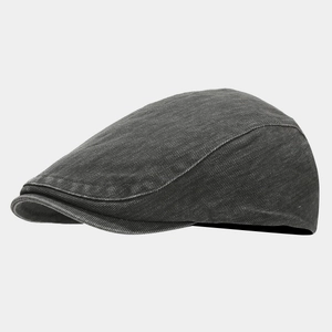 Detail view of charcoal gray washed denim newsboy cap showing twill texture and vintage finish
