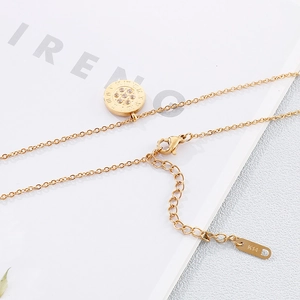Golden Roman numeral pendant necklace with diamonds on a minimalist white background