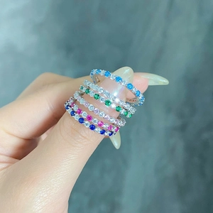 Close-up of hand wearing silver rings with colorful zircon gemstones in various colors