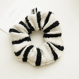 Detailed close-up of French vintage striped tweed scrunchie with woven we brand tag