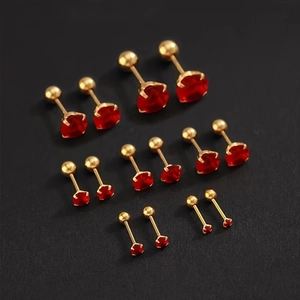 Detail view of red zircon stud earrings set in gold titanium steel with screw ball backs