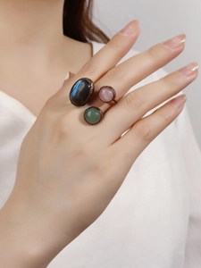 Detail of vintage adjustable rings set with labradorite, rose quartz and green aventurine