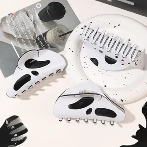 Three spooky black and white Halloween hair claws with ghost patterns in a modern style