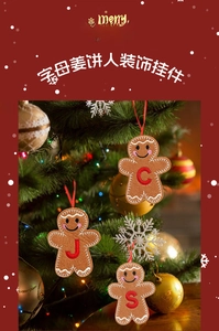 Primo piano di decorazioni omino di pan di zenzero con lettere J, C e S su albero di Natale