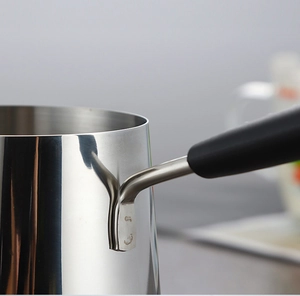 Detail of the heat-resistant handle connection on a stainless steel mini milk pot