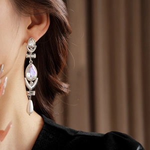 Close-up of silver tassel earrings with iridescent crystals and elegant pearl drops