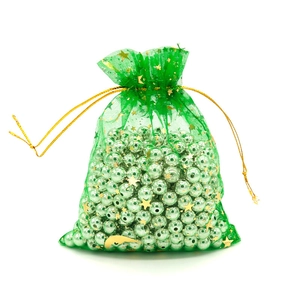 Detailed view of green organza drawstring bag with gold star pattern and metallic beads