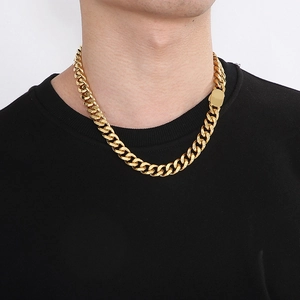 Detail of a bold gold Cuban link necklace with a rectangle clasp worn by a male model