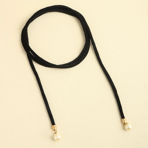 Detail of long black velvet choker with gold-tone tubes and pearl pendants