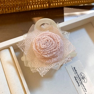 Dettaglio del fermaglio per capelli a rosa in pizzo rosa fatto a mano con resina elegante