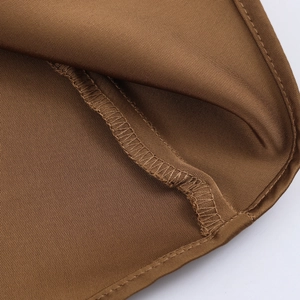 Macro shot showing high-quality texture and stitching of brown satin midi skirt
