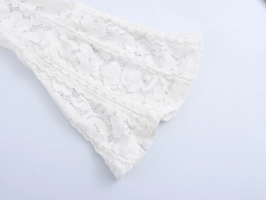 Close-up of white lace flared sleeve with floral and geometric patterns on a mini dress