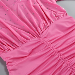 Detail view of pink dress featuring dense silver rhinestones and elegant waist pleats
