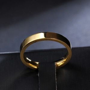 Macro shot of 3mm gold titanium steel ring with polished mirror finish on a black stand