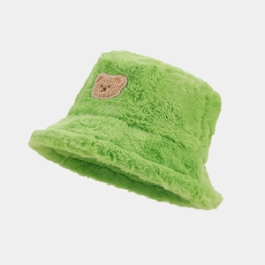 Detail of light green plush bucket hat with cute teddy bear embroidery patch