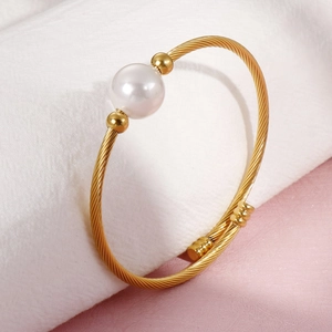 Bracelet minimaliste en fil d'acier inoxydable doré avec une perle blanche sur tissu doux