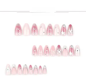 Detail of almond press-on nails with pink cat eye gradient, silver bows and stars