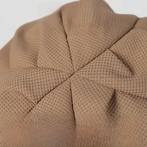 Détails de la casquette gavroche camel avec texture gaufrée et plis artisanaux en relief