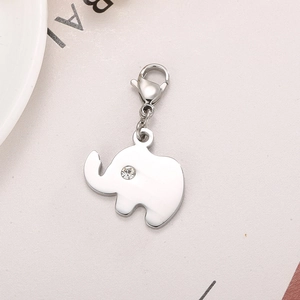 Silver elephant pendant with lobster clasp and sparkling rhinestone on metal surface