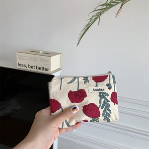 Vue détaillée d'une pochette à rouge à lèvres en toile avec motif de coquelicots rouges