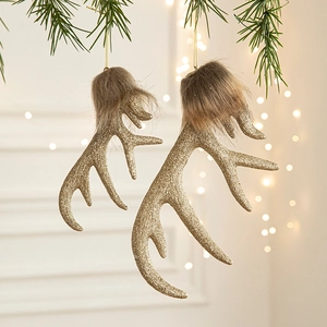 Sparkling gold reindeer antler Christmas ornaments with brown fur hanging on a pine tree