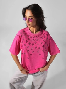Close-up of rose pink oversized cotton T-shirt featuring all-over black H-pattern prints