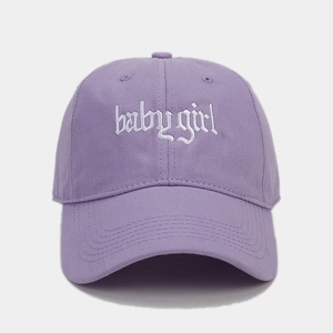 Nahaufnahme der weißen Babygirl-Stickerei auf violetter Baumwoll-Baseballkappe