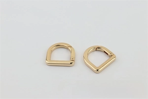 Close-up of a light gold D-ring spring buckle with a polished finish for handbags