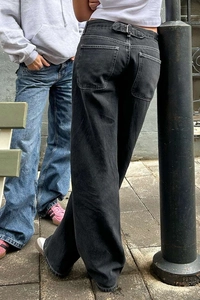 Outdoor street view of high-waisted black wide-leg denim jeans with washed texture