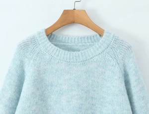 Close-up of soft light blue mohair knit texture and ribbed crewneck collar details
