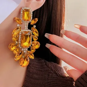 Luxurious gold drop earrings with large amber gemstones and pavé crystal accents