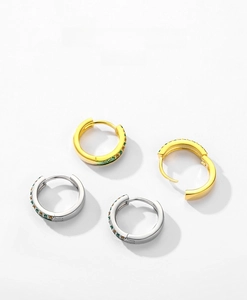 Close-up of S925 sterling silver huggie earrings with green and amber zircon stones