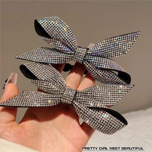 Macro shot of two bow hair clips featuring densely inlaid sparkling rhinestones in silver