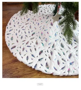 Detail of white plush Christmas tree skirt with colorful metallic feather patterns
