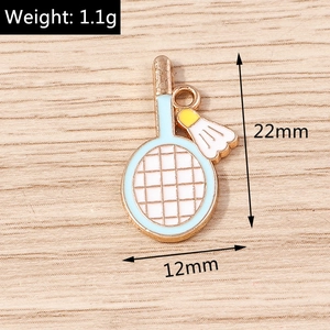 Macro d'un pendentif badminton montrant la taille de 22mm et le poids de 1,1g sur bois