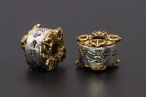 Macro shot of two-tone metal beads with vintage relief patterns and Chinese engraving
