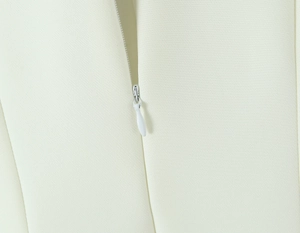 Detailaufnahme des verdeckten Reißverschlusses und elfenbeinfarbenen Webstoffs am Kleid