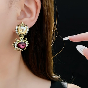 Close-up of vintage gold earrings with champagne and rose crystals on a model
