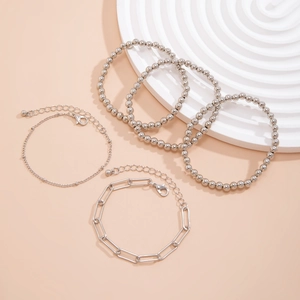 Detailed set of five silver metal bracelets including beaded and paperclip link chains
