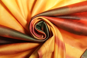 Dettaglio macro del tessuto tie-dye con trama a saia nei colori arancione e verde