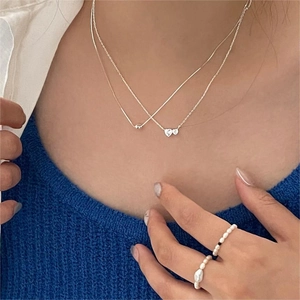 Double-layered 925 sterling silver heart pendant necklace shown on a model neck