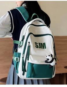 Detail view of American vintage white and green backpack with cute panda plush charm