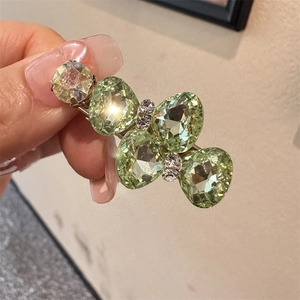 Gros plan détaillé d'une pince à cheveux nœud en cristal vert clair aux pierres facettées