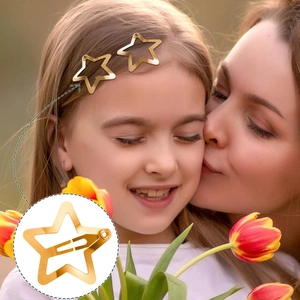 Close-up of dual gold star hair clips on a person's hair for a stylish side look