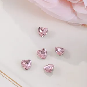 Macro shot of 6x6mm heart-shaped pink crystals with faceted cut for nail art decoration