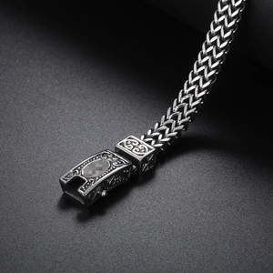 Macro detail of men's stainless steel Franco chain with vintage floral engraving