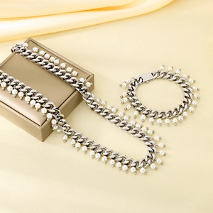 Detail of silver Cuban chain necklace and bracelet set with delicate white pearl drops