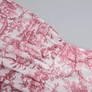 Détail de l'imprimé paysage rouge sur tissu blanc avec plis et coutures de haute qualité